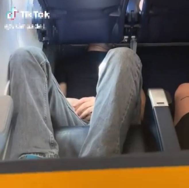항공기 바닥에 등을 댄 채 누워 있는 남성. 출처=틱톡 갈무리