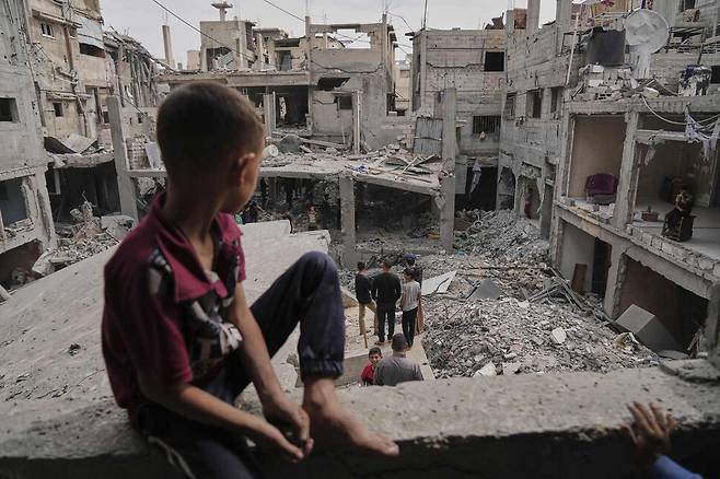 팔레스타인 주민들이 15일(현지시각) 가자지구 칸 유니스에서 이스라엘 공습으로 파괴된 잔해를 살펴보고 있다. 칸 유니스/AP 연합뉴스