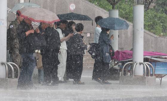 People walk in the rain near Seoul Station in central Seoul on May 16. [YONHAP]