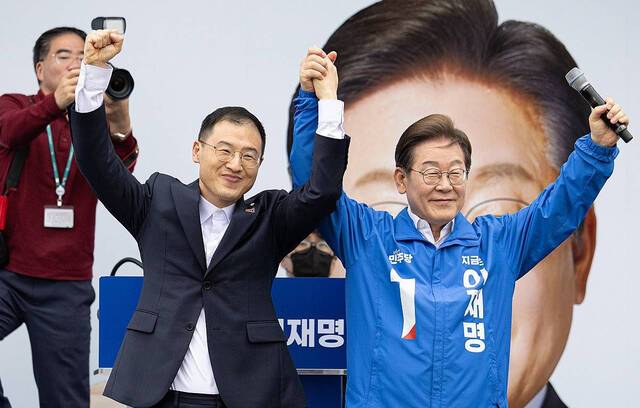 더불어민주당 이재명 대선후보가 16일 전북 익산시 익산역 동부광장에서 열린 유세에서 무소속 김상욱 의원과 손을 들어 인사하고 있다. 사진공동취재단