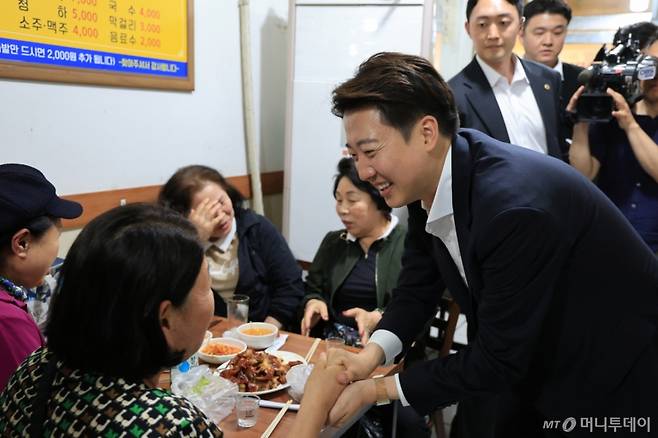 [천안=뉴시스] 박우경 기자=충남권 표심 확보를 위해 충남 천안중앙시장을 찾은 이준석 개혁신당 후보가 한 족발집에서 시민과 인사하고 있다. 2025.5.16.  /사진=박우경