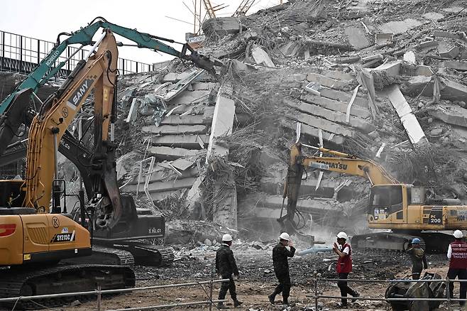 미얀마 강진에 미얀마에서 거리가 1000㎞ 떨어진 태국 방콕에서도 지진 피해를 입었다. 방콕에서 구조팀이 30일(현지시간) 장비를 이용해 건물이 붕괴된 현장을 수습하고 있다. [AFP]
