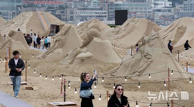 [부산=뉴시스] 하경민 기자 = 15일 부산 해운대구 해운대해수욕장을 찾은 시민과 관광객들이 다양한 모래조각 작품을 구경하고 있다. 해운대구는 오는 16~19일 '2025년 해운대 모래축제'를 개최한다. 올해 20주년을 맞은 모래축제는 '모래로 만나는 K-컬처'를 주제로 14명의 해외 모래 작가가 제작한 총 20여 개의 작품을 선보인다. 모래작품들은 축제 기간 이후인 오는 6월8일까지 전시될 예정이다. 2025.05.15. yulnetphoto@newsis.com