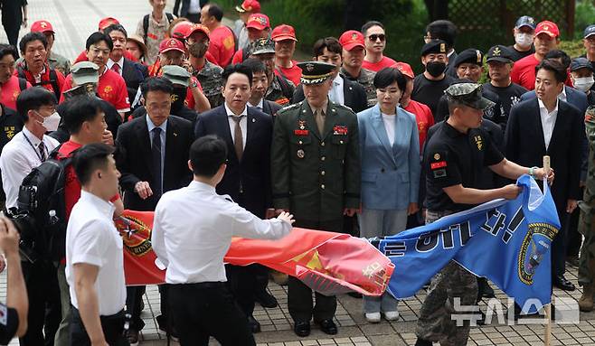 [서울=뉴시스] 김선웅 기자 = 박정훈 해병대 대령이 16일 서울 서초구 서울고등법원에서 열린 채상병 사건 관련 항소심 2차 공판준비기일에 출석하는 중 동행한 해병대 예비역 관계자들이 현수막을 펼치자 법원 방호원에게 제지되고 있다. 2025.05.16. mangusta@newsis.com