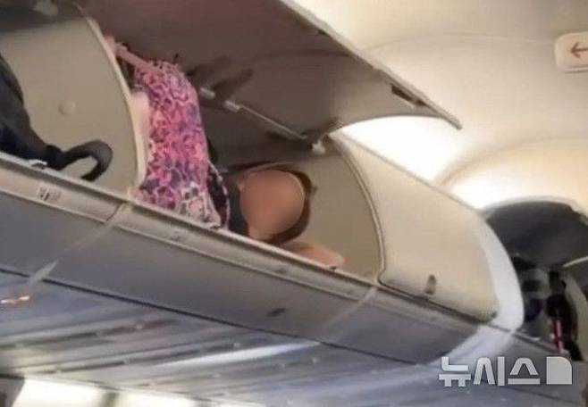 [서울=뉴시스] 지난해에는 비행기 좌석 짐칸에 누워있는 여성의 모습이 SNS에 공개돼 화제가 된 바 있다. (사진=틱톡 캡처)