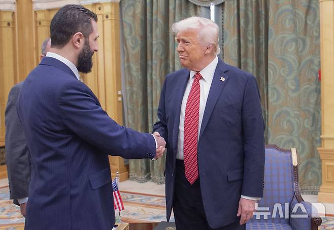 [리야드=AP/뉴시스] 도널드 트럼프 미 대통령(오른쪽)이 지난 14일 사우디아라비아 리야드에서 아흐마드 알-사라 시리아 임시 대통령과 악수하고 있다. 트럼프 대통령이 시리아 제재 해제를 발표하면서 중동 지정학 개편 불씨를 던졌다는 평가가 나온다. 2025.05.16.