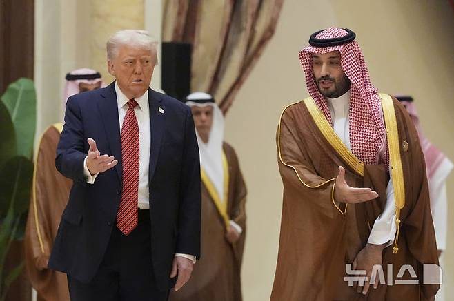 [리야드=AP/뉴시스] 도널드 트럼프(왼쪽) 미국 대통령과 무함마드 빈 살만 사우디 왕세자가 지난 14일(현지 시간) 사우디아라비아 리야드에서 열린 걸프협력회의(GCC) 정상회의에 함께 참석해 GCC 정상들과 단체 사진 촬영장으로 향하고 있다. 2025.05.16.