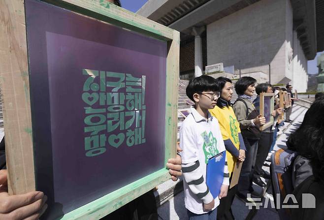 [서울=뉴시스] 김근수 기자 = 기후정치바람 회원들이 지난달 15일 서울 종로구 세종문화회관 앞에서 열린 기후 단일 의제 대선 TV 토론회 촉구 기자회견에서 캠페인 슬로건이 적힌 실크스크린을 들고 서 있다. 2025.04.15. ks@newsis.com