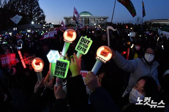 윤석열 대통령 탄핵소추안이 가결된 지난해 12월 14일 서울 여의도 국회 앞에서 열린 촛불집회에 참석한 시민들이 탄핵이 가결되자 환호하고 있다. 류영주 기자