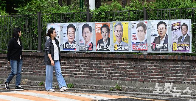 제21대 대통령선거 선거벽보를 보고 있는 시민들. 류영주 기자