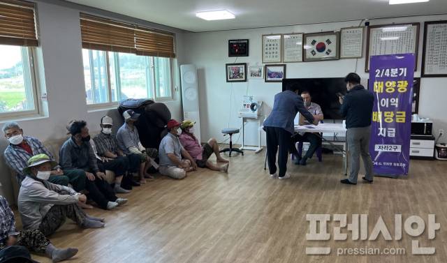 ▲신재생에너지 이익공유제 시행으로 발생한 배당금을 주민들이 마을 경로당에 모여 지급받고 있다.ⓒ신안군