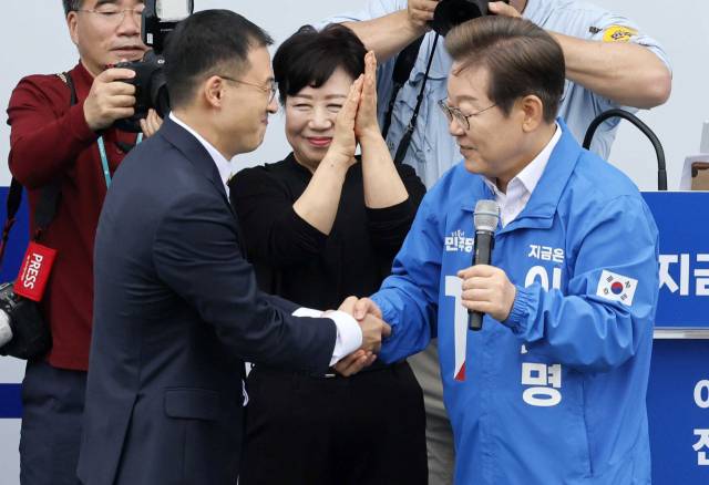 이재명 더불어민주당 대선후보가 16일 전북 익산시 익산역 동부광장에서 열린 유세에서 김상욱 무소속 의원과 악수하고 있다. 익산=오승현 기자