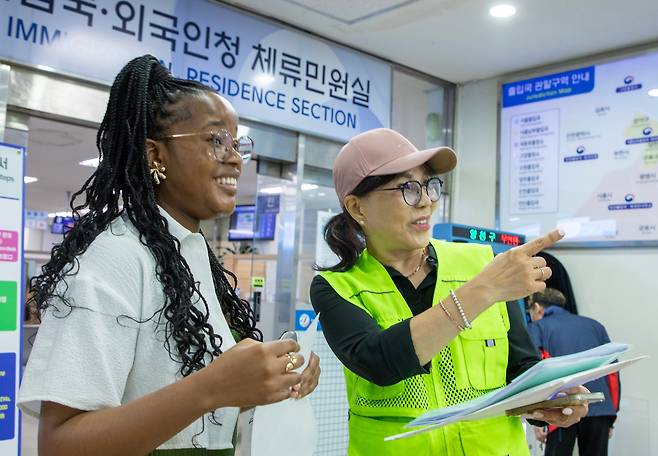14일 오후 서울 양천구 서울출입국·외국인청에서 국적회복 자원봉사자 박연희씨가 남아공에서 온 민원인 마탈루씨의 외국인등록증 발급을 돕고 있다. 국적회복 자원봉사단은 지난 4월부터 이민경험을 활용해 외국인 이민자들을 돕고 있다./조인원 기자