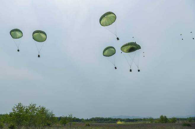 지상군구성군사령부는 지난 9일부터 16일까지 2·5군단(군수지원여단, 특공연대) 및 2신속대응사단과 육군항공사령부, 공군작전사령부, 공중기동정찰사령부, 공군군수사령부, 미해병대 1해병보급단 등 한미 양국군 장병 220여 명이 참가한 '2025년 전반기 연합합동 공중재보급 훈련'을 실시했다. 이번 훈련은 전시 열악한 지상 병참선을 극복하고 우리 군의 작전지속지원능력을 유지 및 발전시키기 위해 계획됐다. 사진은 수송기가 재보급 물자를 목표지점에 공중 투하하고 있는 모습. 육군 제공