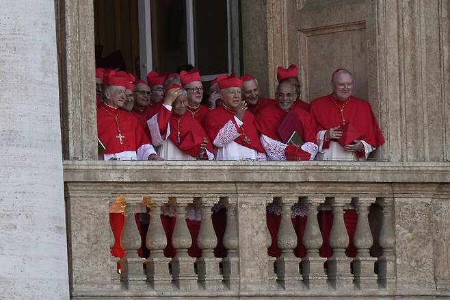 지난 8일(현지시각) 바티칸 성 베드로 대성당의 발코니 중 한 곳에서 이틀 만에 콘클라베에서 새 교황 레오 14세를 선출한 추기경들이 환한 표정으로 광장을 내려다보고 있다. AP 연합뉴스