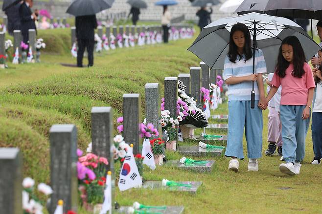 16일 광주 5·18 민주묘지를 찾은 어린이들이 우산을 쓴 채 걷고 있다.