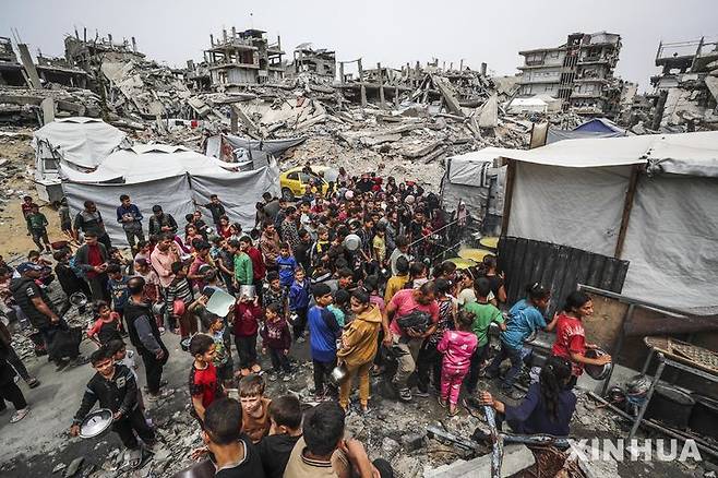 [ 가자시티=신화/뉴시스] 가자지구의 가자시티에 있는 한 임시급식소에 4월 24일(현지시간) 수 많은 팔레스타인 피난민들이 몰려 들어 무료 급식을 받기 위해 아우성을 치고 있다.  유엔구호기구인 인도주의업무조정국(OCHA)는 민간인 살상과 끝없는 대피 명령 속에서 극한의 기아위기가 닥쳐왔다며 이스라엘군의 국경 봉쇄 해제와 구호품 반입 허가를 재차 촉구했다. 2025.04. 25.