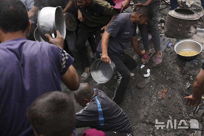 [자발리아=AP/뉴시스] 15일(현지 시간) 가자지구 북부 자발리아의 한 급식소에 팔레스타인 주민들이 음식을 배급받기 위해 몰려들고 있다. 유엔 세계식량계획(WFP)은 가자지구 내 대부분 빵집이 문을 닫았고, 자선 급식소들 또한 운영을 중단했으며, 식량 재고가 모두 소진돼 기근이 임박했다고 경고했다. 2025.05.16.