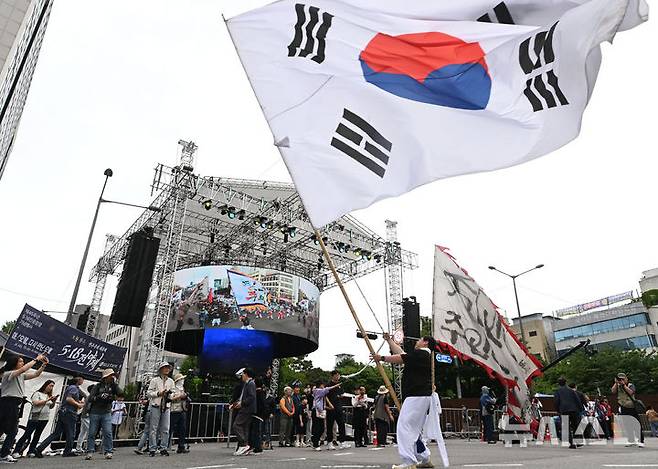 [광주=뉴시스] 이영주 기자 = 17일 오후 광주 동구 금남로에서 5·18민주화운동 45주기를 기념하는 풍물패가 대형 태극기를 흔들고 있다. 2025.05.17. leeyj2578@newsis.com