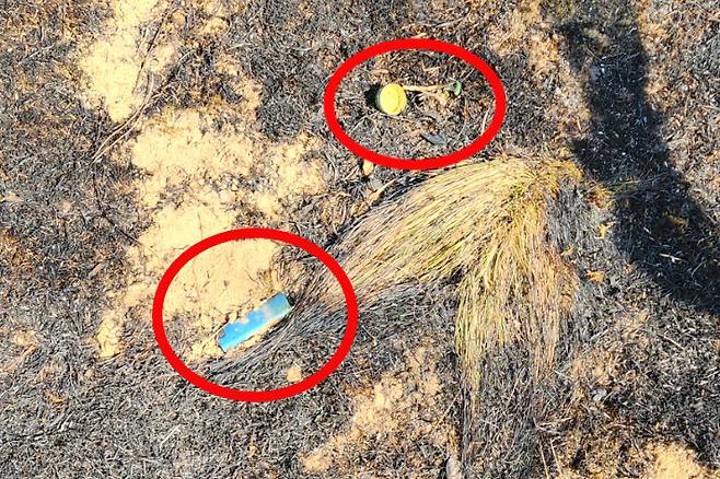 산불 원인으로 추정되는 라이터와 소주 뚜껑. 괴산1리 김정호 이장 제공