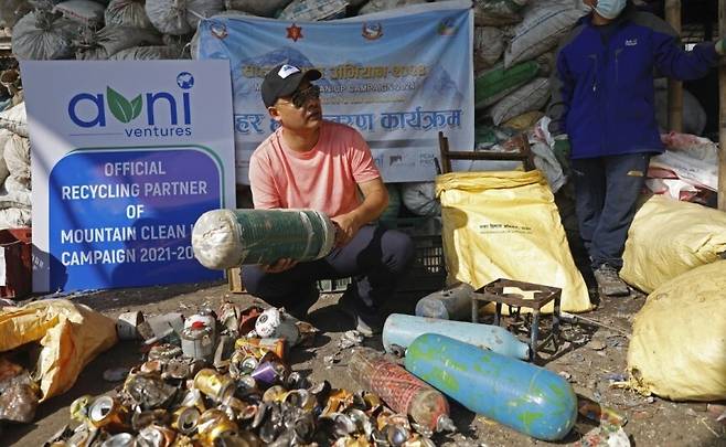 지난해 7월 네팔 카드만두의 쓰레기 재활용업체인 아그니벤처 직원이 에베레스트에서 수거해 온 쓰레기를 분류하고 있다. AP/뉴시스