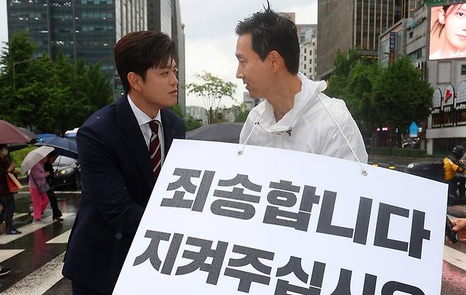국민의힘 김용태 비상대책위원장(왼쪽)이 16일 서울 종로구 세종대로사거리를 찾아 지지호소 피켓팅을 하고 있는 김기흥 전 대통령실 부대변인을 격려하고 있다. 연합뉴스