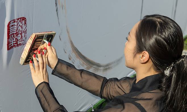 김소영 작가가 강원도 강릉시 홍제동 글씨당에서 캘리그래피 퍼포먼스를 마친 뒤 글씨당 도장을 찍고 있다.