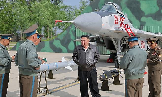 북한 노동당 기관지 노동신문은 17일 “경애하는 김정은동지께서 5월 15일 조선인민군 근위 제1공군사단 관하 비행연대를 방문하시고 공군비행대들의 반항공전투 및 공습훈련을 지도했다”고 보도하며 관련 사진을 공개했다. 사진에는 김 위원장 뒤쪽으로 신형 장거리 공대공미사일과 정밀유도폭탄으로 추정되는 무기들과 미그-29 전투기가 있다. 노동신문·뉴스1