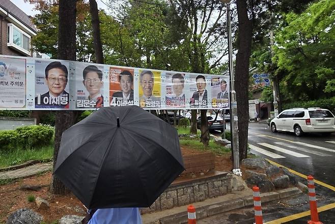 ▲ 제21대 대통령 선거를 불과 16일 앞두고 선거 벽보 앞에선 시민이 각당의 후보들의 공약을 살펴보고 있다.