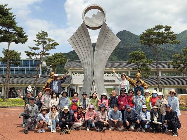 신기단이 청도신화랑풍류마을에서 기념촬영하고 있다.