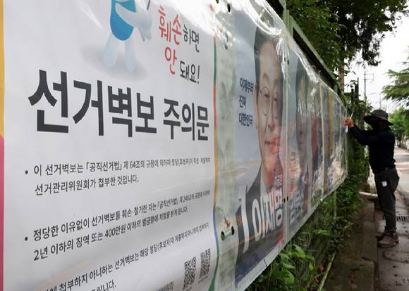 제21대 대통령 선거 벽보 부착을 시작한 15일 전북선거관리위원회 관계자가 전주시 완산구 효자동의 한 아파트 입구에 후보자 벽보를 붙이고 있다. 2025.5.15 [사진=연합뉴스]