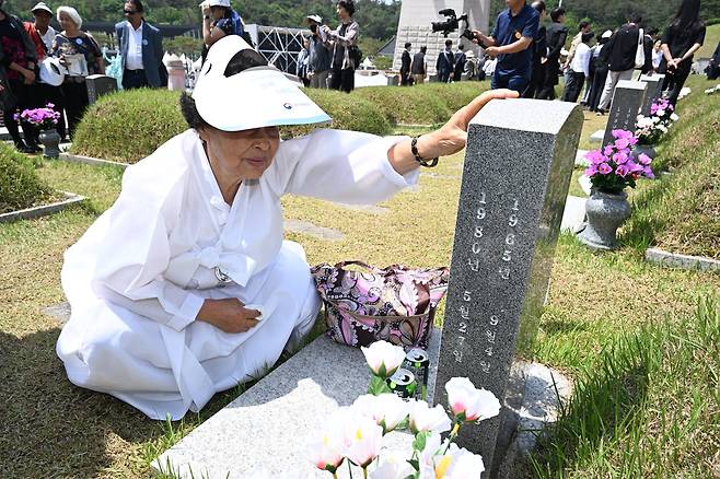 18일 오전 광주 북구 5·18 민주묘지에서 제45주년 5·18 민주화운동 기념식을 마친 유족이 묘비를 어루만지고 있다. 연합뉴스