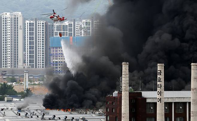 A helicopter tries to put out a fire at the Kumho Tire factory in Gwangju on May 17. [NEWS1]