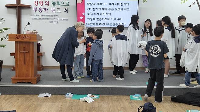 임채란 권사가 경기도 성남 동문교회 아동부실에서 아이들과 함께 말씀 암송을 하고 있다.