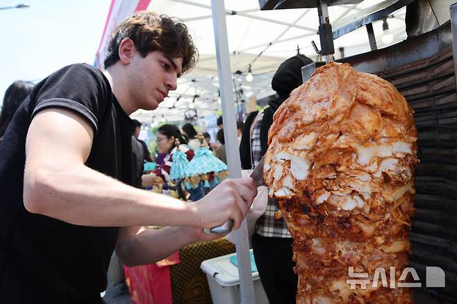 [서울=뉴시스] 김금보 기자 = 18일 서울 성북구 성북동 주민센터 건너편 성북로 일대에서 열린 '제 17회 성북세계음식축제 누리마실'에서 각국 요리사들이 대표음식을 만들고 있다. 2025.05.18. kgb@newsis.com