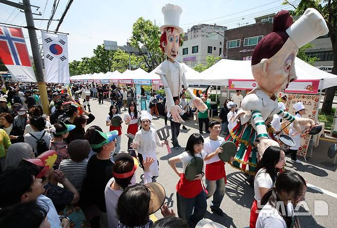 [서울=뉴시스] 김금보 기자 = 18일 서울 성북구 성북동 주민센터 건너편 성북로 일대에서 열린 '제 17회 성북세계음식축제 누리마실'에서 서커스 퍼포먼스 퍼레이드 공연이 펼쳐지고 있다. 2025.05.18. kgb@newsis.com