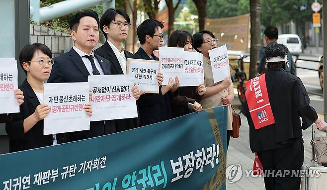 내란 재판 비공개 재판부 규탄 기자회견 (서울=연합뉴스) 김인철 기자 = 14일 서울중앙지방법원 동문 앞에서 열린 12.3 내란 재판 비공개하는 지귀연 재판부 규탄 기자회견에서 군인권센터, 참여연대, 민주사회를 위한 변호사모임(민변) 등 참석자들이 손팻말을 들고 있다. 오른쪽은 아크로비스타로 향하는 윤석열 전 대통령 지지자. 2025.5.14 yatoya@yna.co.kr