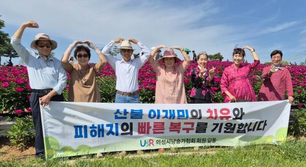 의성시낭송가협회 낭송가들이 18일 의성군 금성면 조문국사적지 작약꽃밭에서 '산불 이재민 치유와 피해자 복구 기원' 응원의 메시지를 전하고 있다. 의성시낭송가협회