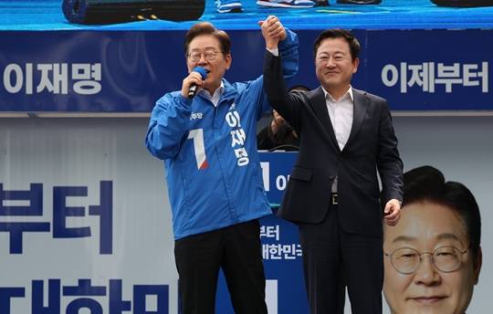 김용남 전 의원이 그제(17일) 광주 서구 김대중컨벤션센터 광장에서 이재명 후보와 손을 맞잡고 있다. (출처=뉴스1)