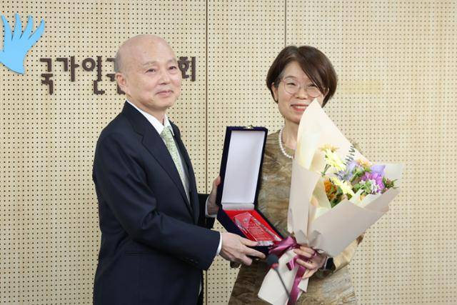 남규선(오른쪽) 국가인권위원회 상임위원이 19일 서울 중구 인권위에서 열린 이임식에서 안창호 위원장으로부터 감사패를 받고 있다. 뉴스1
