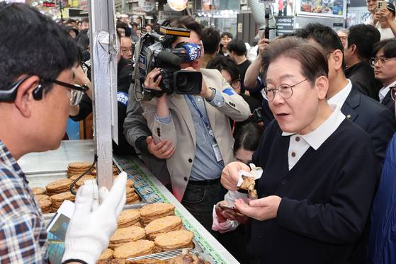 더불어민주당 이재명 대선 후보가 '골목골목 경청투어' : 단양8경편'에 나선 4일 충북 단양군 단양구경시장에서 떡갈비를 사먹으며 상인과 대화하고 있다. 연합뉴스
