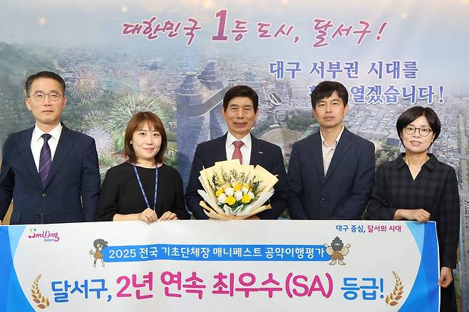 ‘2025 민선 8기 전국 기초자치단체장 공약이행 및 정보공개 평가’에서 2년 연속 최고 등급(SA)을 달성한 후 이태훈 달서구청장(가운데) 등이 이를 축하하고 있는 모습. 달서구 제공