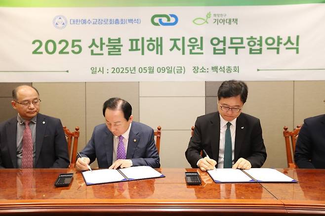 최창남(오른쪽) 기아대책 회장과 이규환(가운데) 예장백석 총회장이 경북 지역 산불 피해 교회 지원을 위한 업무협약서에 서명하고 있다. 기아대책 제공