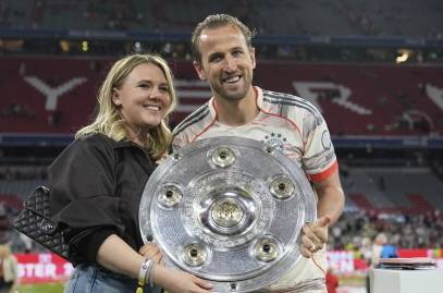 바이에른 뮌헨의 해리 케인이 지난 11일 독일 분데스리가 우승을 확정지은 뒤 아내와 함께 트로피를 든 채 활짝 웃고 있다. AP 뉴시스