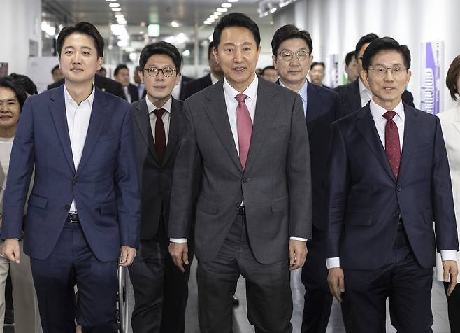 오세훈 서울시장(가운데)과 국민의힘 김문수 대선후보(오른쪽), 개혁신당 이준석 대선후보를 비롯한 내빈들이 19일 서울 중구 서울시청에서 열린 ‘약자와 동행하는 서울 토론회’에 입장하고 있다. <연합>