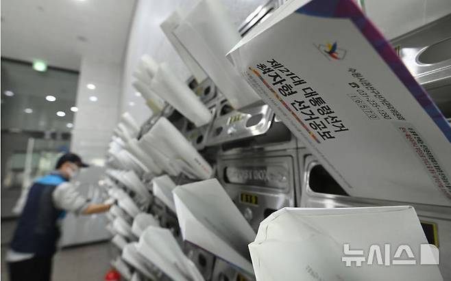 [수원=뉴시스] 김종택 기자 = 18일 경기 수원시 권선구 한 오피스텔 건물에서 우체국 집배원이 제21대 대통령선거 안내문과 선거공보물을 우편함에 넣고 있다. 2025.05.18. jtk@newsis.com