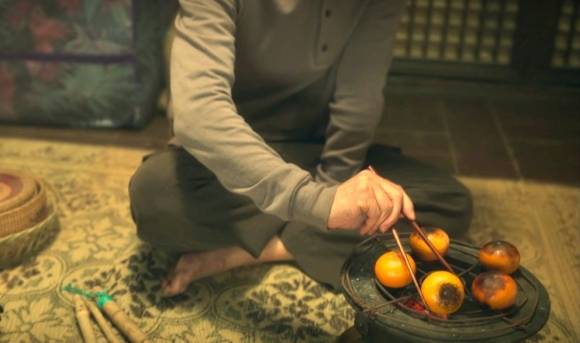 넷플릭스 드라마 ‘폭싹 속았수다’의 한 장면. 제주산 감귤을 껍질째 화롯불에 올려 굽고 있다. 넷플릭스 자료