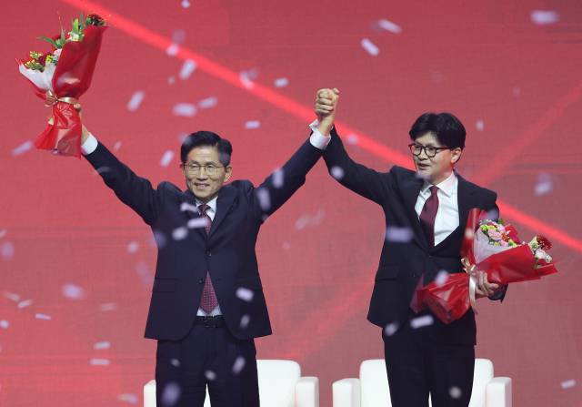 국민의힘 대선 후보로 선출된 김문수 후보가 3일 경기 고양시 킨텍스에서 열린 국민의힘 전당대회에서 꽃다발을 받은 뒤 한동훈 후보와 함께 인사하고 있다. 연합뉴스