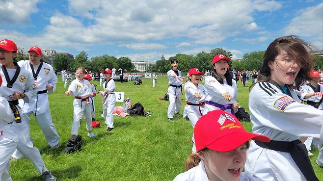 미국 백악관 앞서 열린 태권도 축제 (워싱턴=연합뉴스) 김동현 특파원 = 국기원이 18일(현지시간) 한미동맹 72주년을 기념하기 위해 워싱턴DC 백악관 인근 공원에서 개최한 한마음 태권도 축제에서 참가자들이 '태극 1장'을 함께하고 있다. 2025.5.18