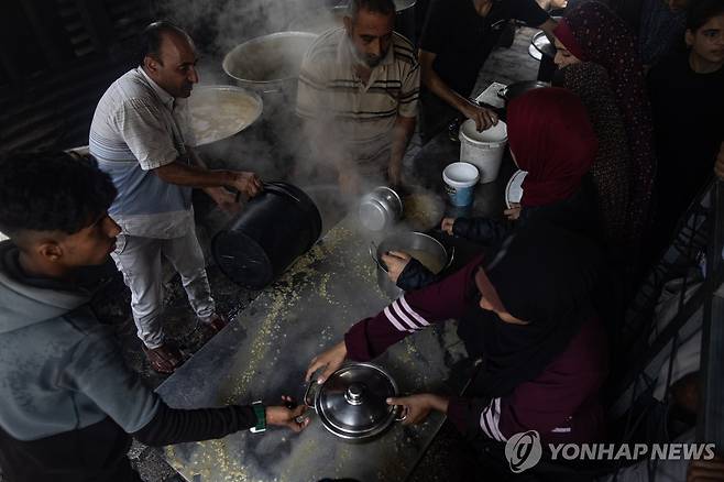 가자지구 굶주림 위기 고조 (EPA 연합뉴스) 19일(현지시간) 가자지구에서 팔레스타인 피란민들이 식량 배급을 받고 있다. 2025.5.19 photo@yna.co.kr